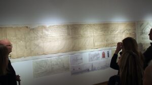 Dažnai vien iš idealistinių paskatų architekto kurtas urbanistinis pasaulis yra sklidinas savito miestietiško vitalumo su griausmingai ūkiančiais garlaiviais upėse, žvaliai plerpiančiais lėktuvais danguje, o krantinėse, gatvėse ir aikštėse – klegančiais miestiečiais. Parodos ekspozicijos fragmentas. Foto: A.Bružo.